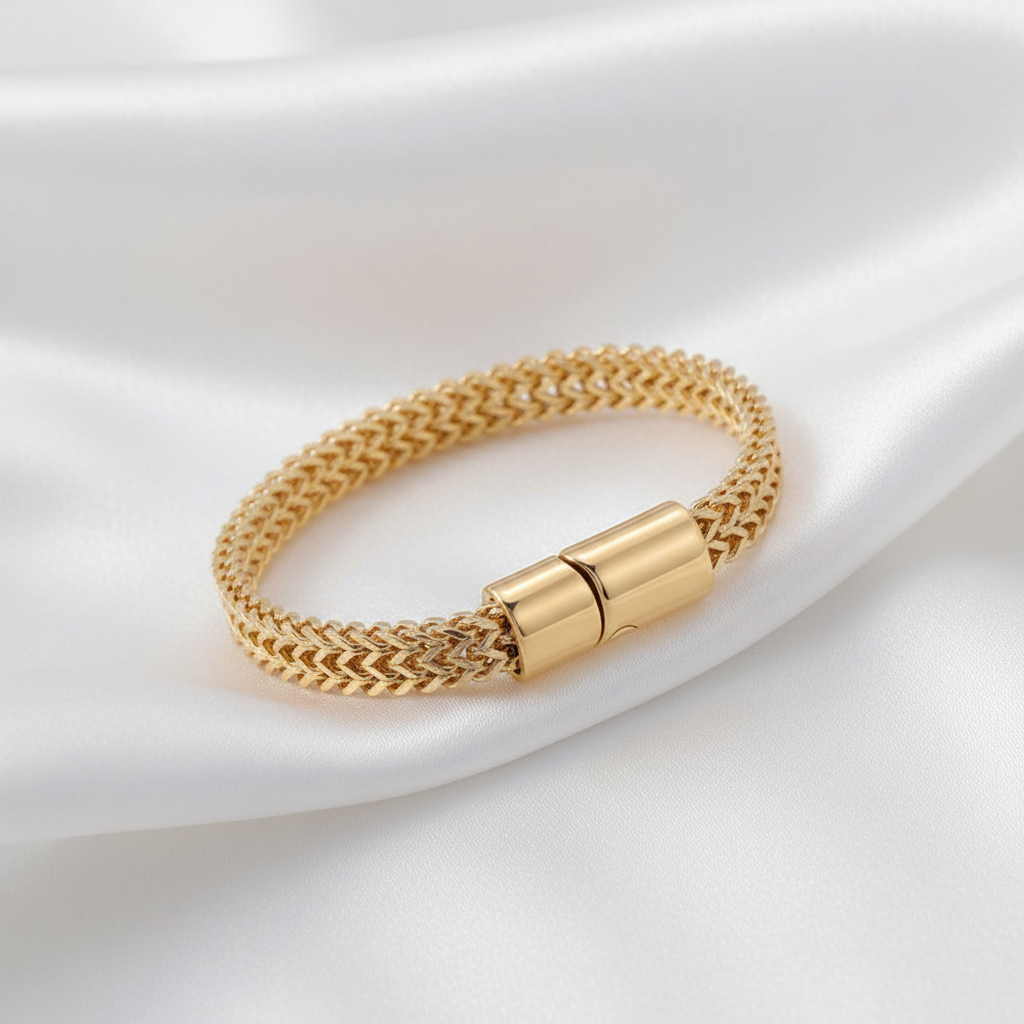 Elegant guldarmband på vit silkesbakgrund