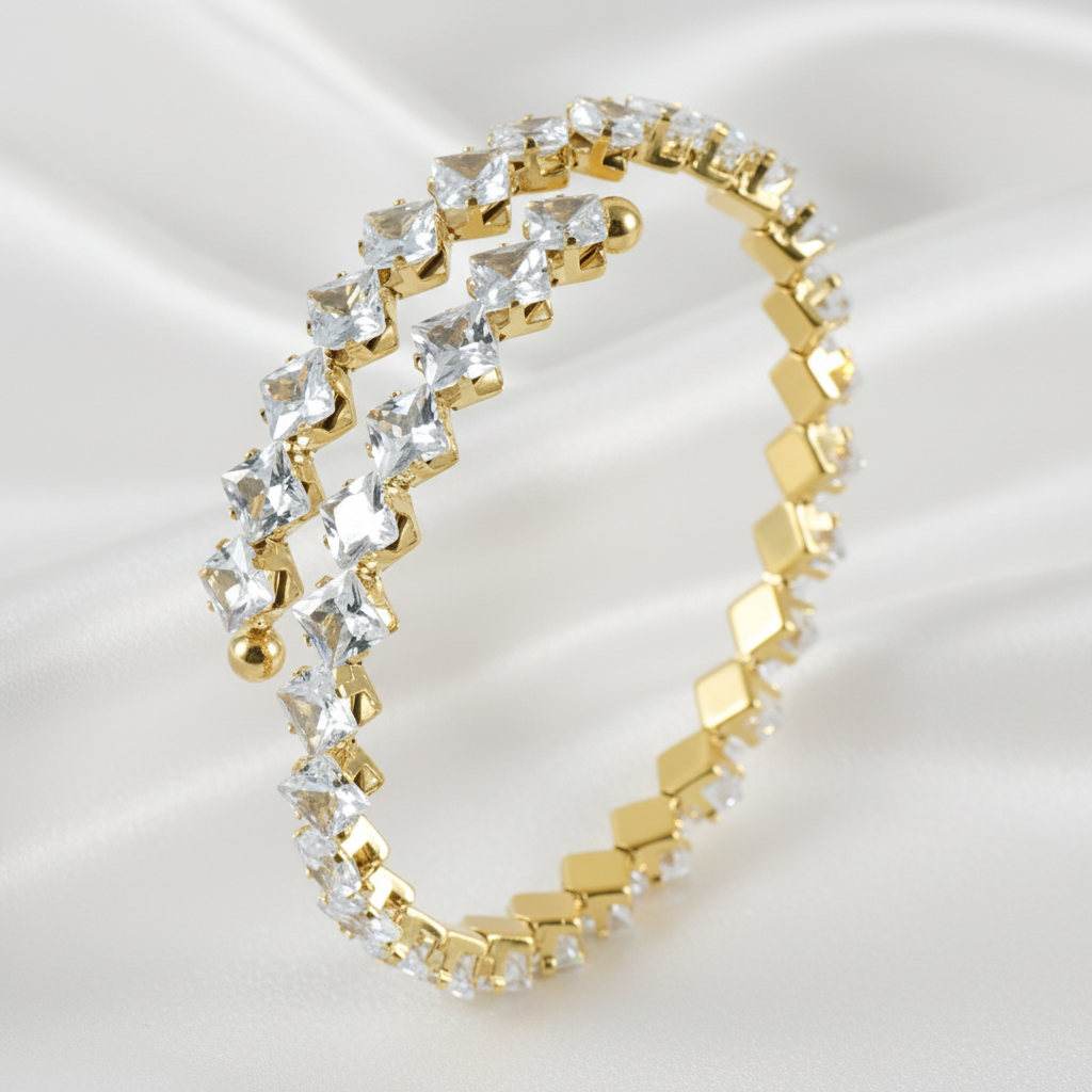 Guldigt armband med klara stenar på vit silk