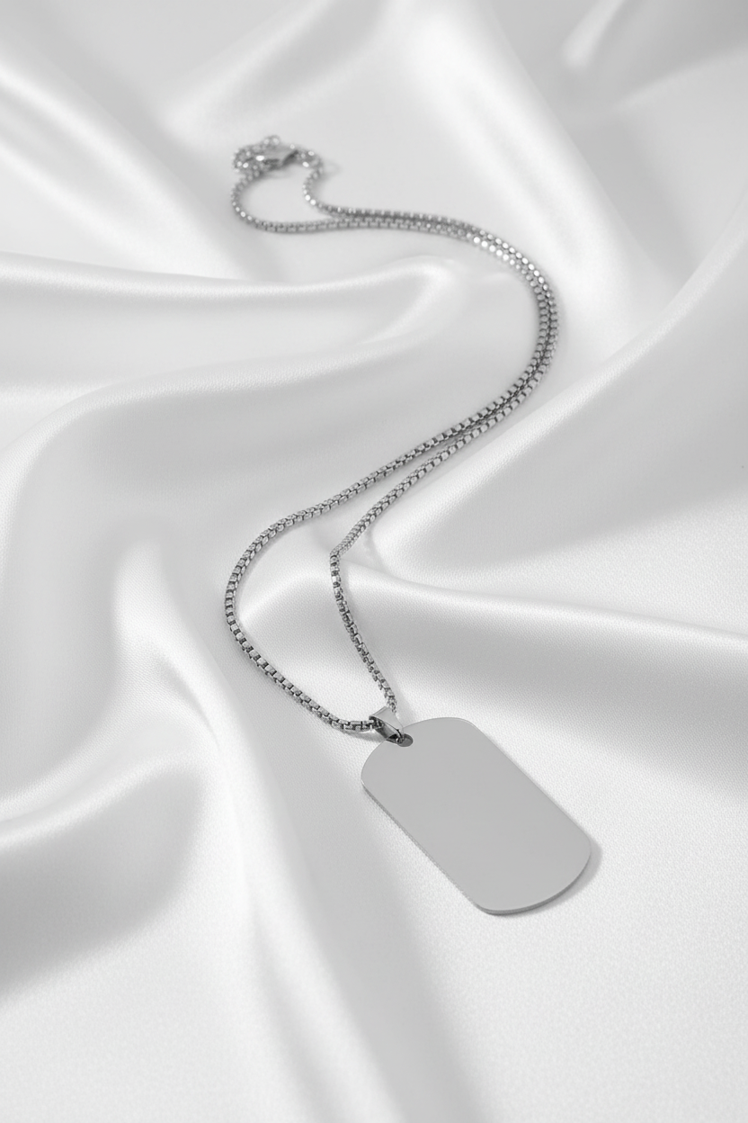 Silverbricka med hel kedja på vit silkesbakgrund