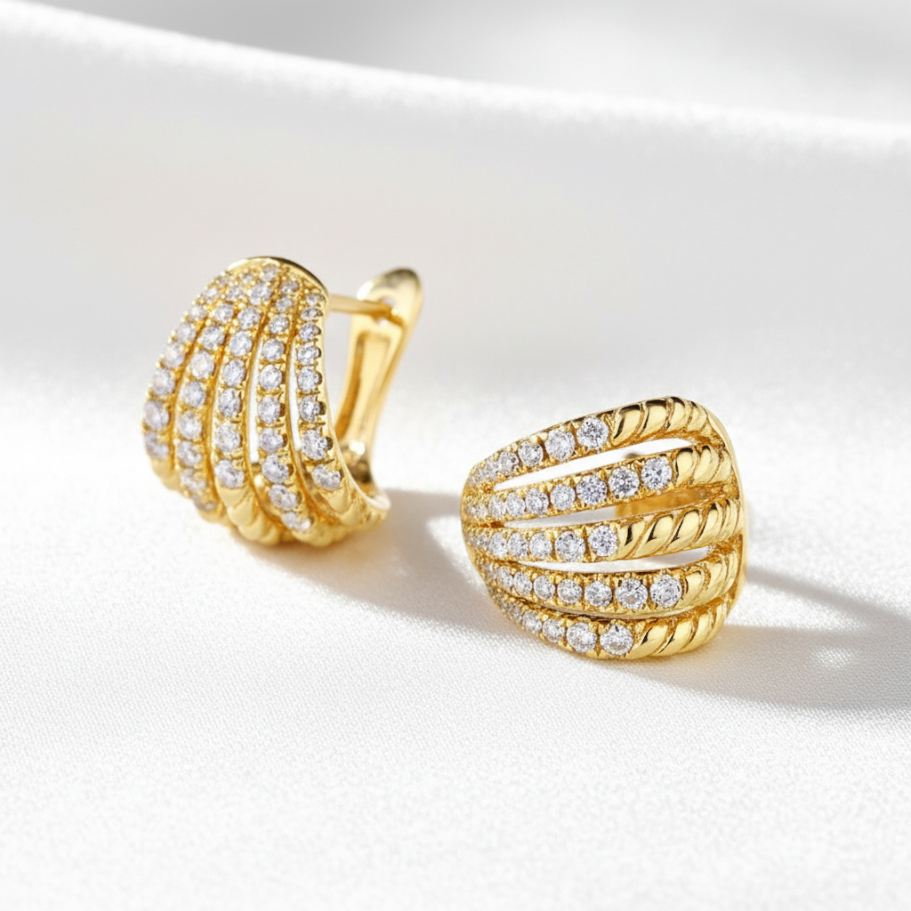 Guldpläterade örhängen på vit silkesbakgrund