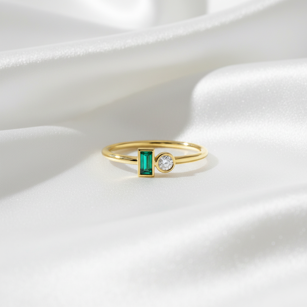 Guldring med smaragd och diamant på vit silkesbakgrund