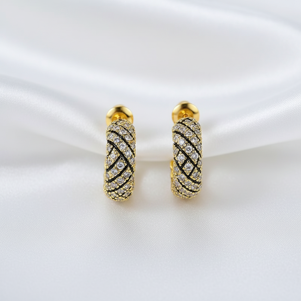 Örhängen med korsad design på vit silkesbakgrund