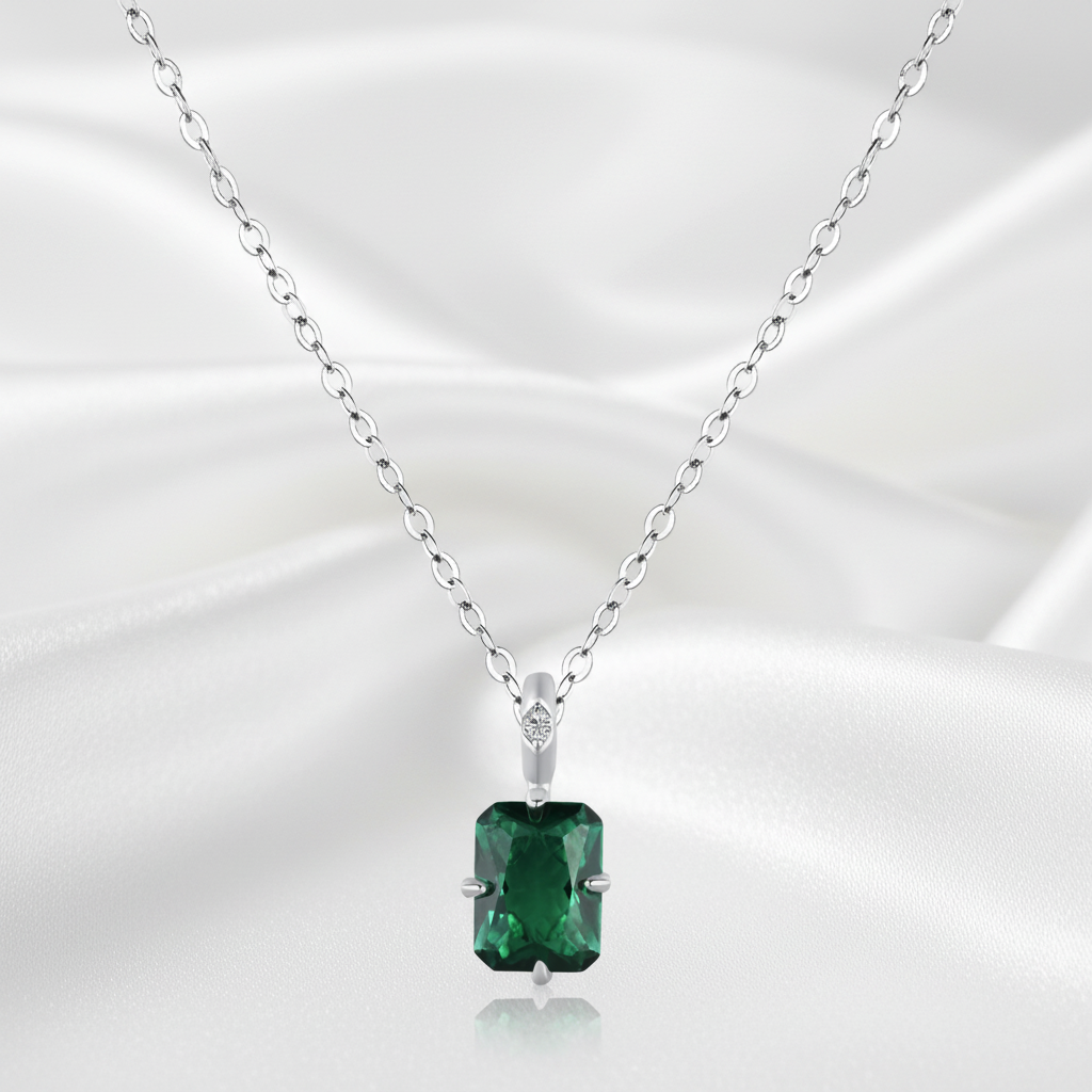 Smaragdhalsband på vit silkesbakgrund